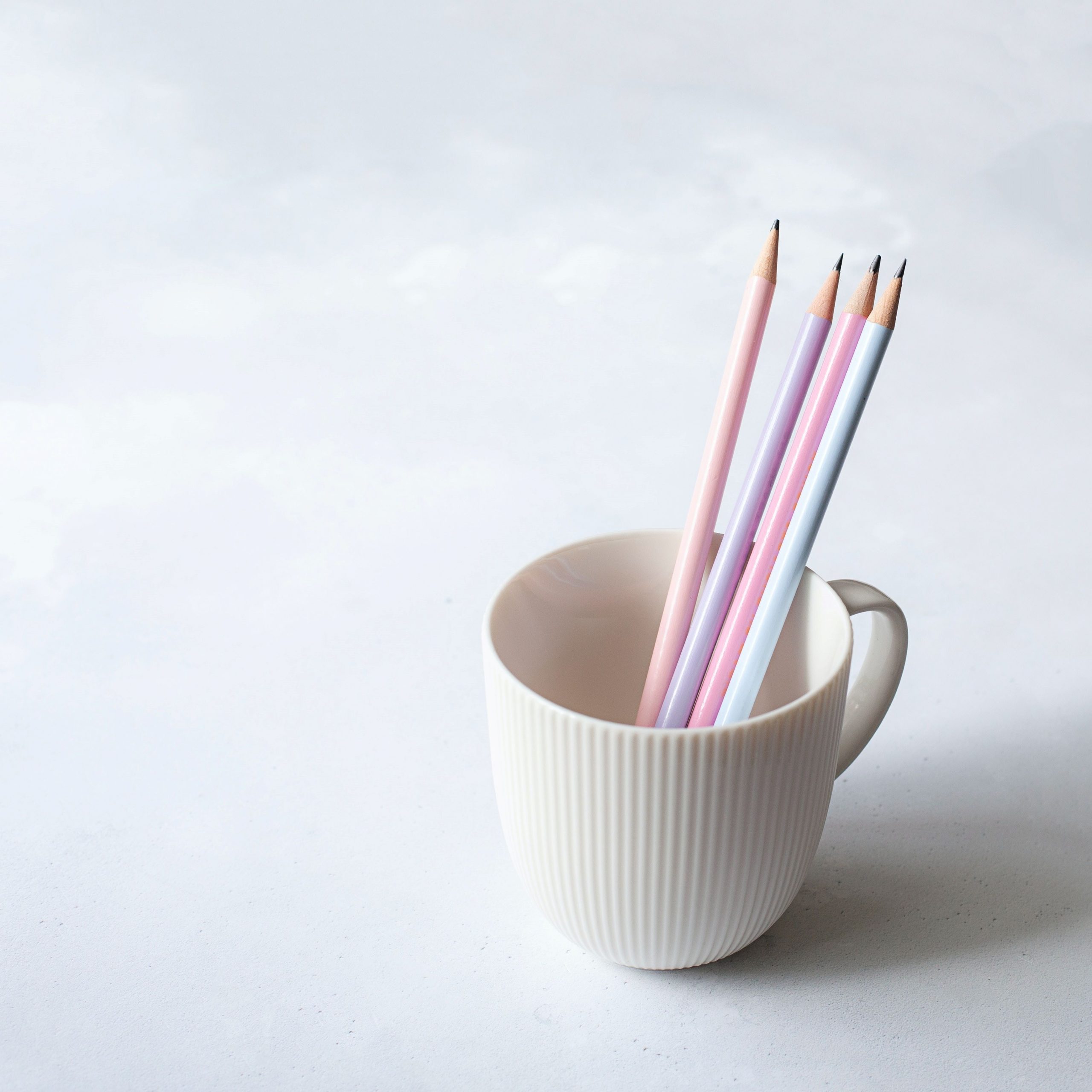 SEO mini audit. White cup with four pink pencils